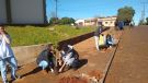 Estudantes de Caibaté plantam mudas frutíferas ao lado do Ginásio de Esportes